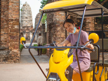 Portrait of smiling boy holding yellow cart