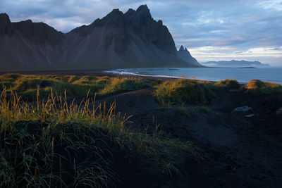 Scenic view of sea and mountains against sky