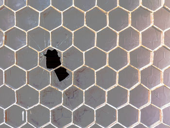 Full frame shot of broken glass window seen through metal