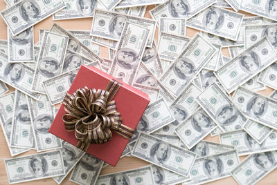 High angle view of gift box with paper currencies on table