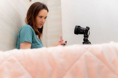 Young woman photographing camera