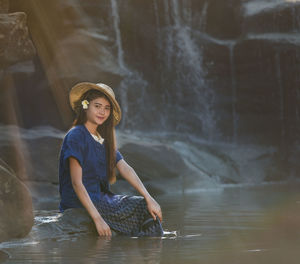 Portrait of young woman wearing straw hat in forest