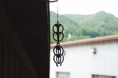 Close-up of electric lamp hanging on building