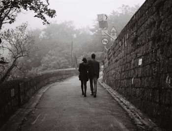 Rear view of woman walking on road