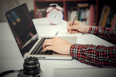 Midsection of man using laptop on table