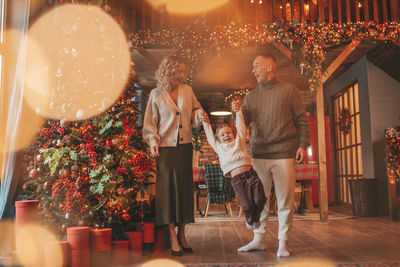 Candid authentic happy family during wintertime together enjoying holidays at wooden lodge at xmas