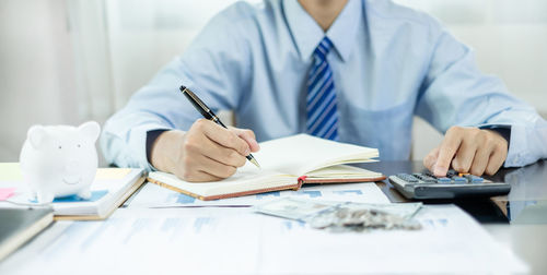 Midsection of doctor working on table