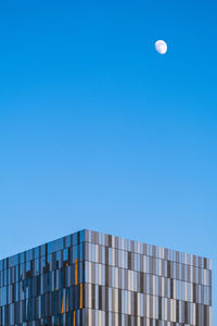 Low angle view of modern building against blue sky