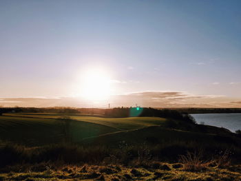 Scenic view of field against sky during sunset
