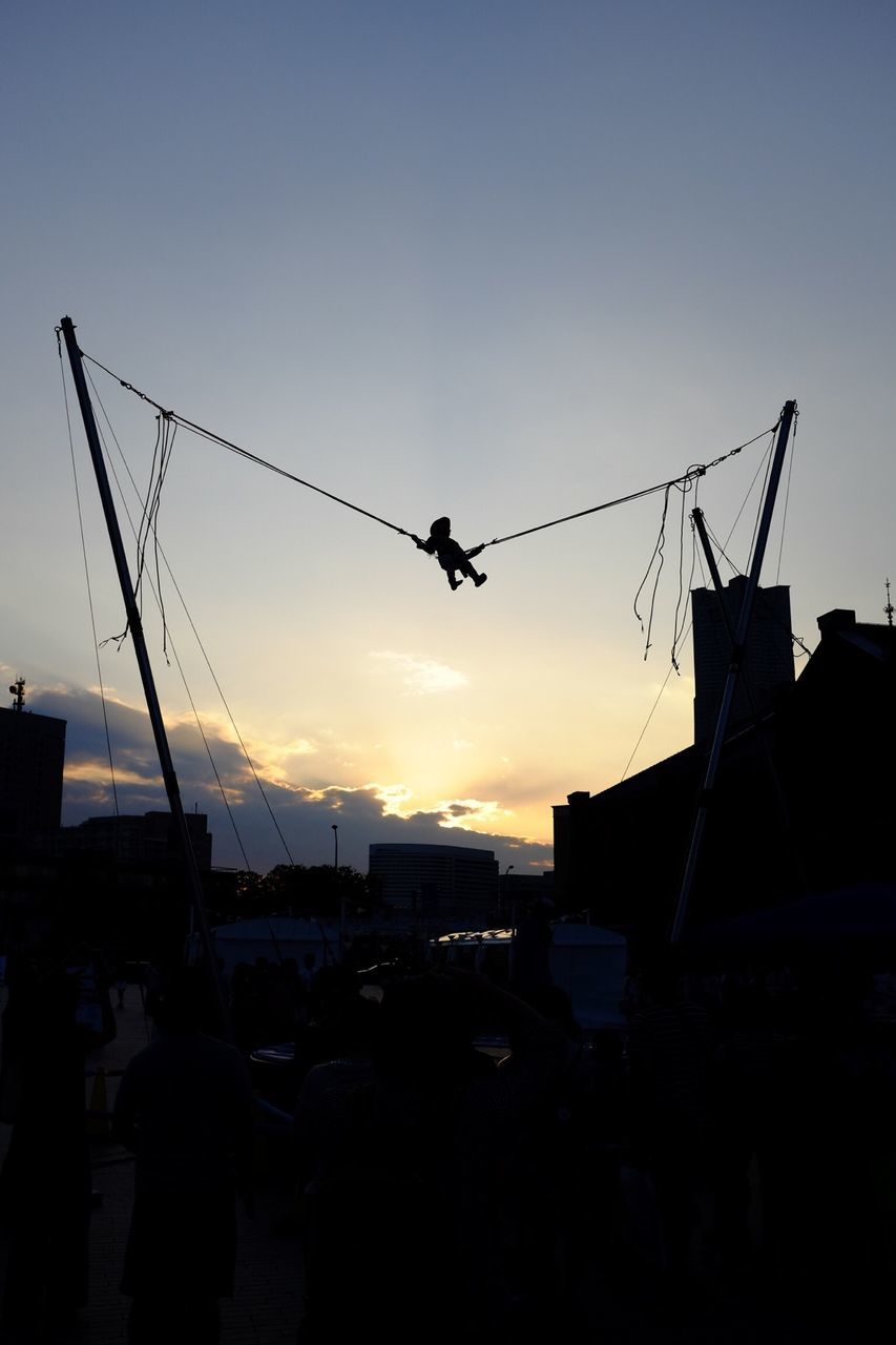 silhouette, sunset, building exterior, built structure, architecture, low angle view, sky, crane - construction machinery, flying, bird, construction site, clear sky, animal themes, animals in the wild, development, transportation, orange color, wildlife, crane, outdoors