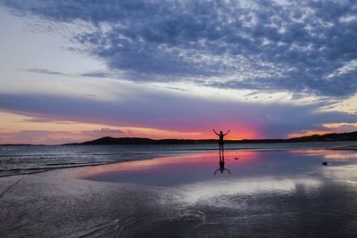 Scenic view of sea against cloudy sky at sunset
