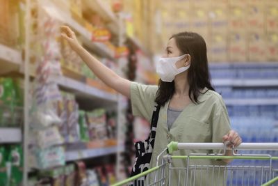 Full length of woman wearing mask at store