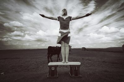 Rear view of woman standing on field