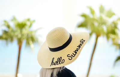 Close-up of portrait of person wearing hat against trees