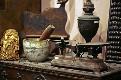 Rusty weighing scale and mortar and pestle on table