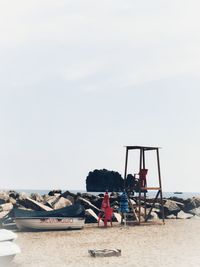 People at beach against sky