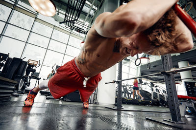 Full length of muscular man working out at gym