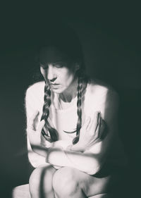 Close-up of young woman with eyes closed against black background