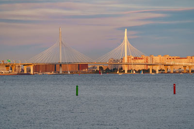 Bridge over sea against sky during sunset