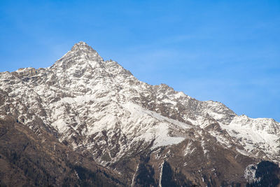 Scenic view of snowcapped mountains against blue sky