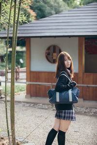 Portrait of smiling young woman standing outdoors