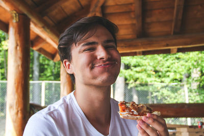 Portrait of young man eating food at restaurant