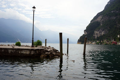 Scenic view of sea by mountains against sky