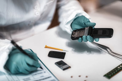 Close-up of man repairing mobile phone