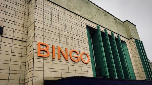 Low angle view of text on building against sky