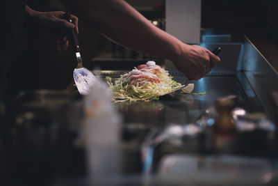 Midsection of person preparing food in kitchen