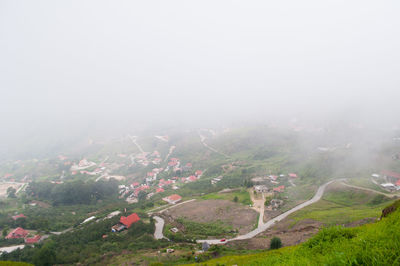 High angle view of houses on mountain during foggy weather