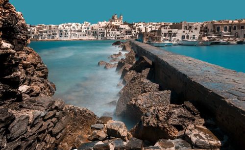 Scenic view of sea by city against sky