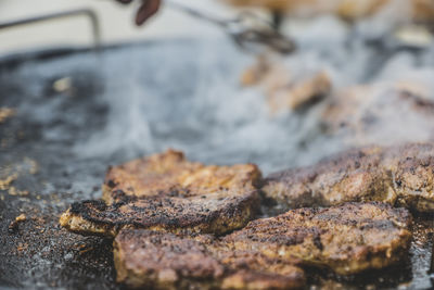 Close-up of steak frying in pan