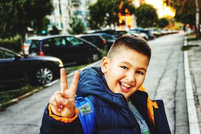 Portrait of young boy standing in city