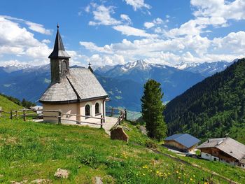 Traditional building by mountains against sky