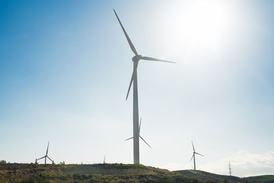 Low angle view of windmill on field against sky