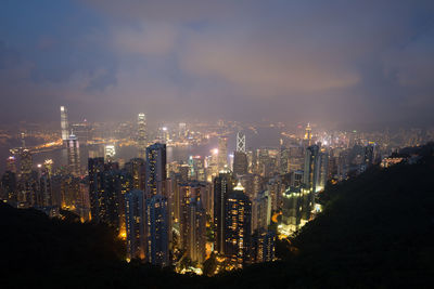 Illuminated buildings in city against sky at night