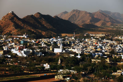 Residential district and mountains against clear sky