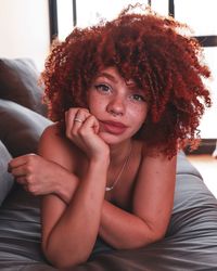 Portrait of young woman lying at home