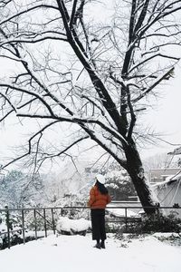 Rear view of man walking on snow covered landscape