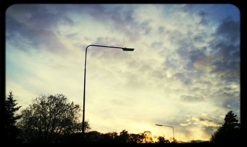 Low angle view of street light against cloudy sky