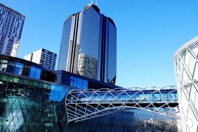 Low angle view of buildings against clear blue sky