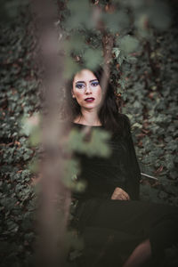 Portrait of young woman sitting on field