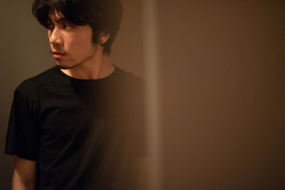 Portrait of young man looking away at home