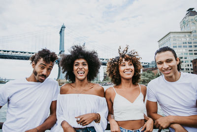 Friends standing with manhattan bridge in background