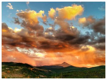 Scenic view of dramatic sky over landscape during sunset