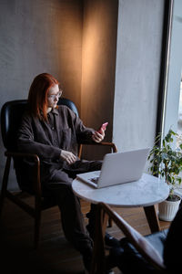 Businesswoman using mobile phone at cafe