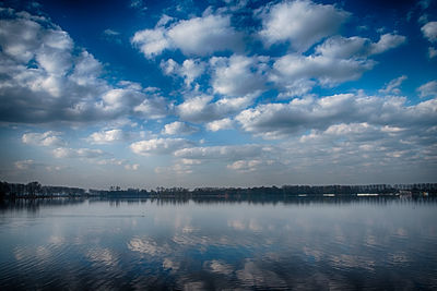 Scenic view of lake against sky in city