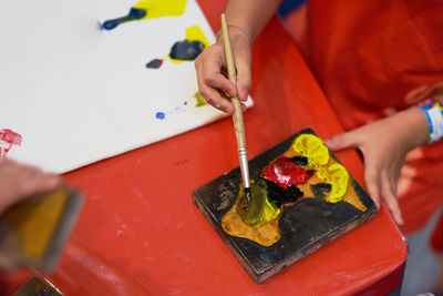 Midsection of boy painting on table