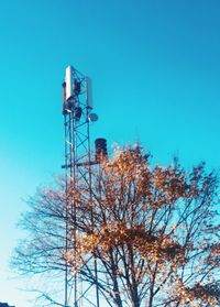 Low angle view of communications tower against clear blue sky